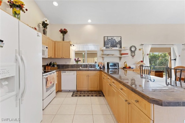 kitchen featuring light tile patterned flooring, white appliances, kitchen peninsula, and light brown cabinets