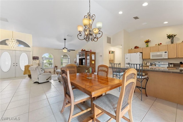 dining space featuring french doors, ceiling fan with notable chandelier, light tile patterned floors, and lofted ceiling