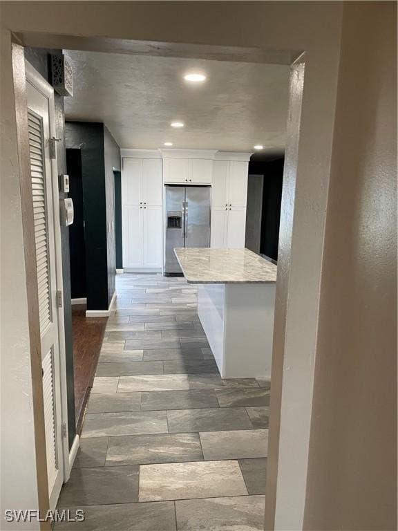 kitchen featuring white cabinetry and stainless steel fridge with ice dispenser