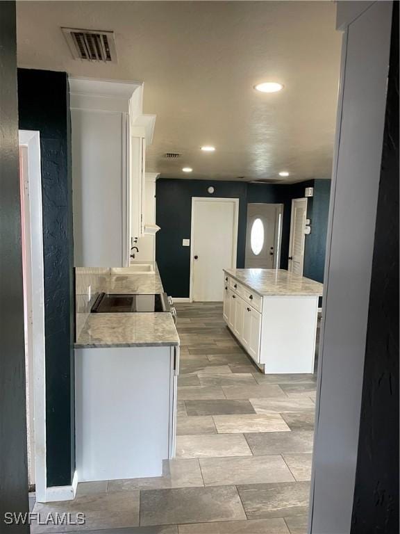 kitchen with white cabinets and light stone countertops