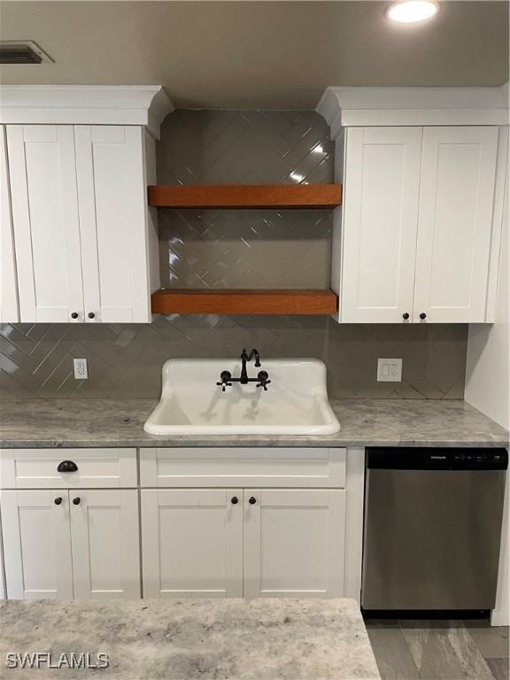 kitchen with white cabinetry, dishwasher, light stone countertops, sink, and decorative backsplash