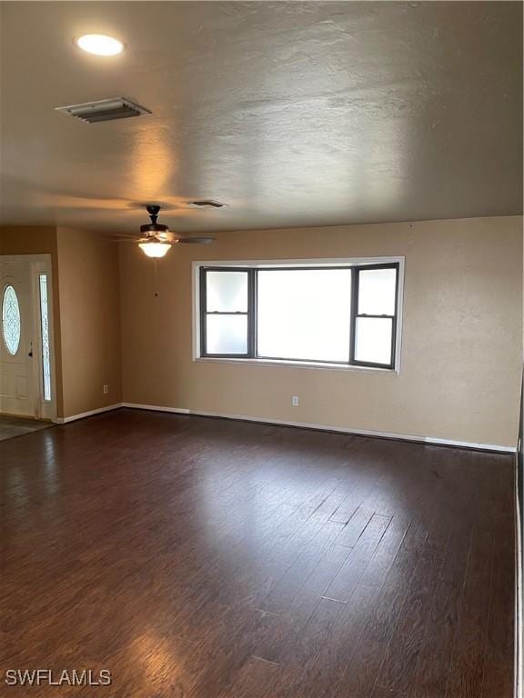 spare room featuring ceiling fan and dark hardwood / wood-style floors