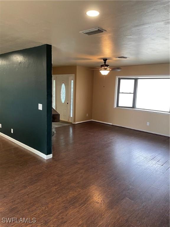 empty room with dark hardwood / wood-style flooring and ceiling fan