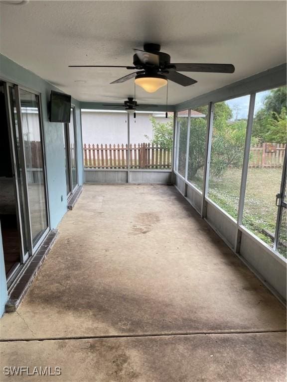 unfurnished sunroom with ceiling fan