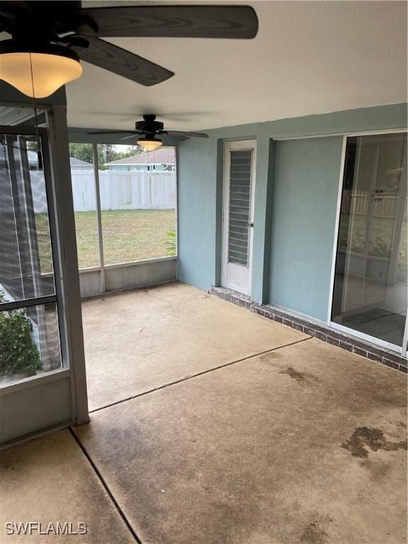 unfurnished sunroom with ceiling fan