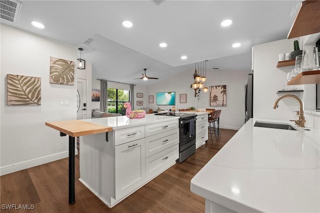 kitchen with a center island, white cabinets, sink, appliances with stainless steel finishes, and decorative light fixtures