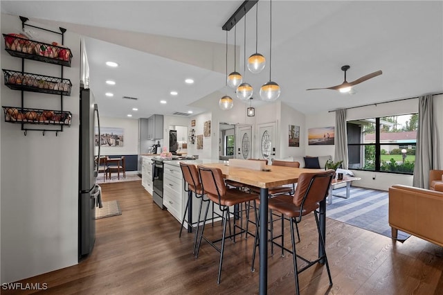 dining area featuring ceiling fan, dark hardwood / wood-style flooring, and lofted ceiling