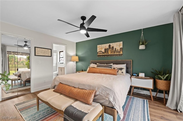 bedroom with connected bathroom, ceiling fan, and hardwood / wood-style floors