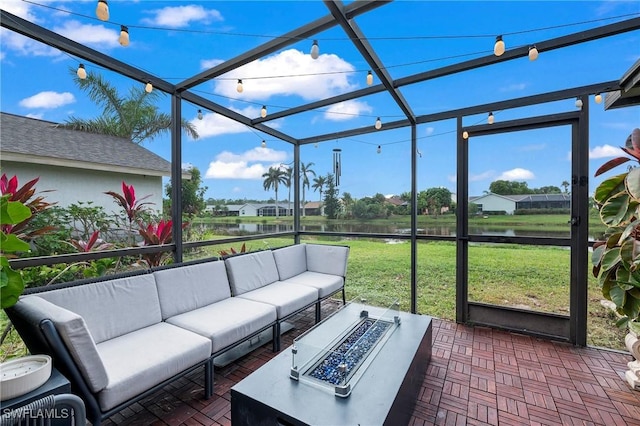 view of patio with a water view and an outdoor living space with a fire pit