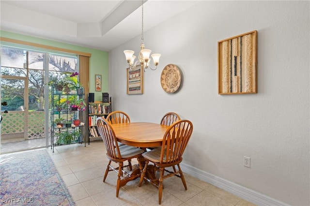 tiled dining room featuring a raised ceiling and a chandelier