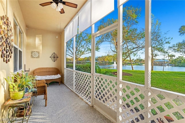 sunroom / solarium featuring a water view and ceiling fan