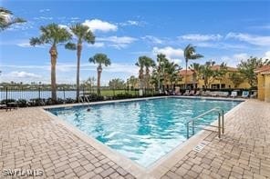 view of pool with a water view and a patio