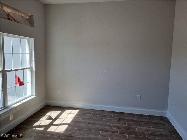 spare room featuring wood finish floors and baseboards