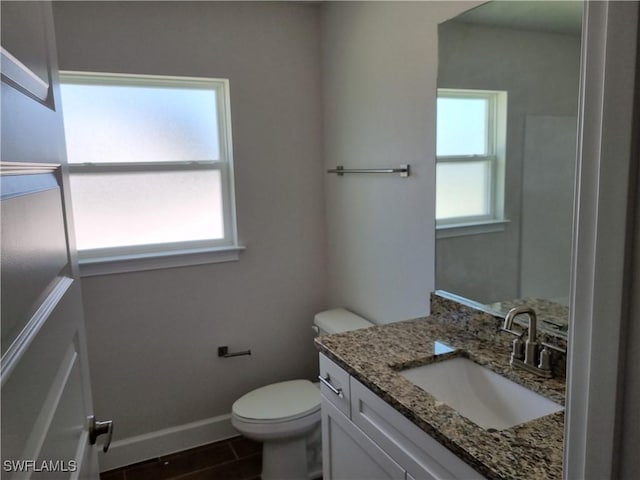 125 NW 9th Ter, Cape Coral, FL 33993 - bathroom with vanity, toilet, baseboards, and wood finished floors