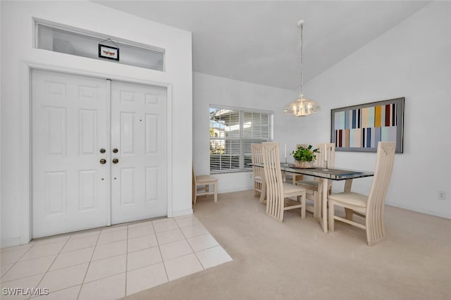 carpeted dining space with vaulted ceiling