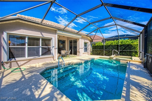 view of swimming pool featuring glass enclosure, an in ground hot tub, and a patio