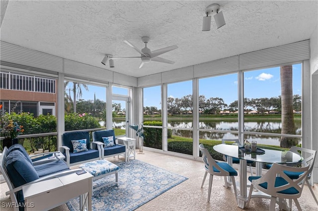 sunroom / solarium featuring ceiling fan, a water view, and plenty of natural light