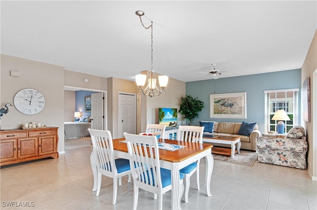 tiled dining room featuring ceiling fan with notable chandelier