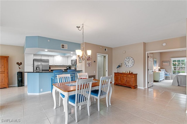 dining area featuring light tile patterned flooring and a chandelier