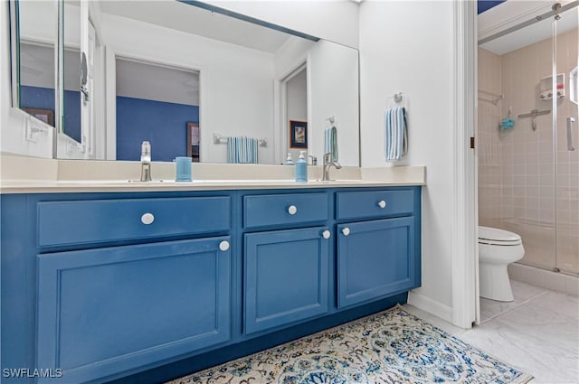 bathroom with vanity, toilet, and a shower with door