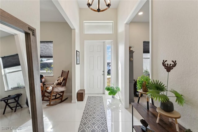 tiled entryway featuring an inviting chandelier