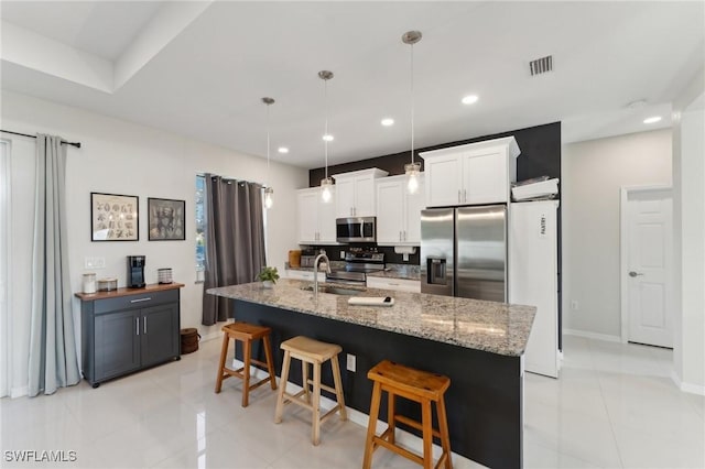 kitchen featuring a spacious island, hanging light fixtures, light tile patterned floors, white cabinetry, and stainless steel appliances