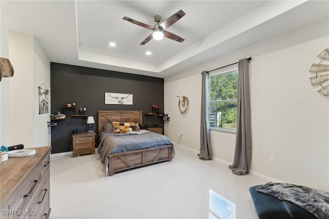 bedroom with a raised ceiling and ceiling fan