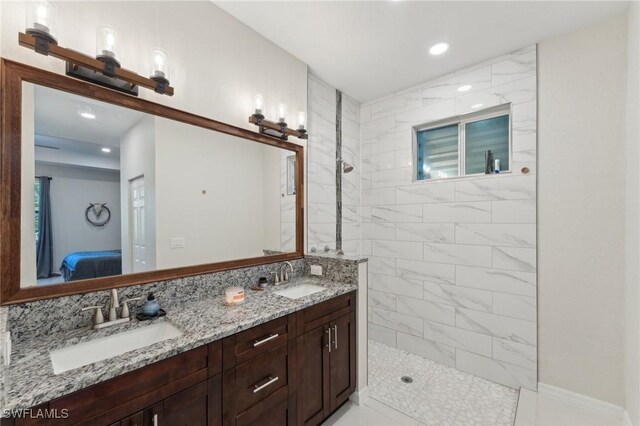 bathroom featuring tiled shower and vanity