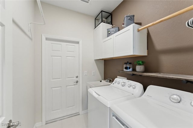 clothes washing area with cabinets, sink, and washing machine and clothes dryer