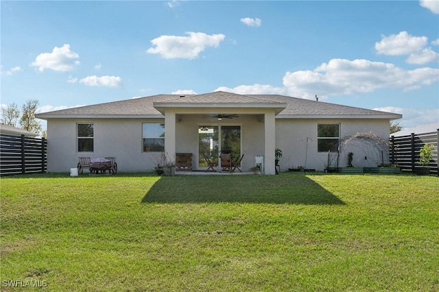 rear view of property with a lawn and ceiling fan