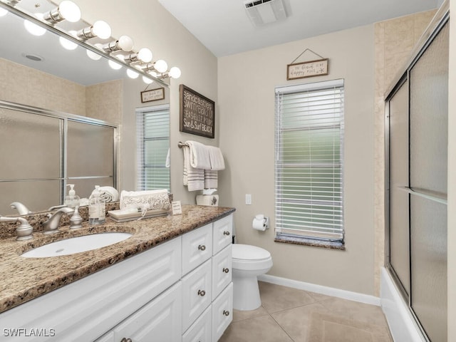 full bathroom with tile patterned floors, shower / bath combination with glass door, vanity, and toilet