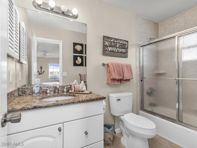 full bathroom featuring ceiling fan, vanity, combined bath / shower with glass door, and toilet