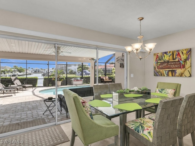 dining space with plenty of natural light, a water view, and ceiling fan with notable chandelier