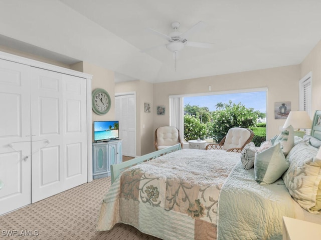 bedroom with ceiling fan, light colored carpet, and two closets