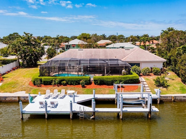 dock area with glass enclosure, a yard, and a water view