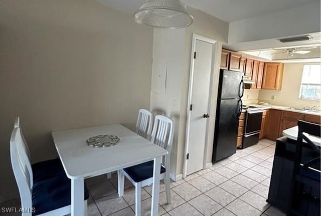 kitchen with range with electric stovetop, black fridge, and light tile patterned floors