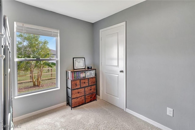 bedroom with multiple windows and light colored carpet