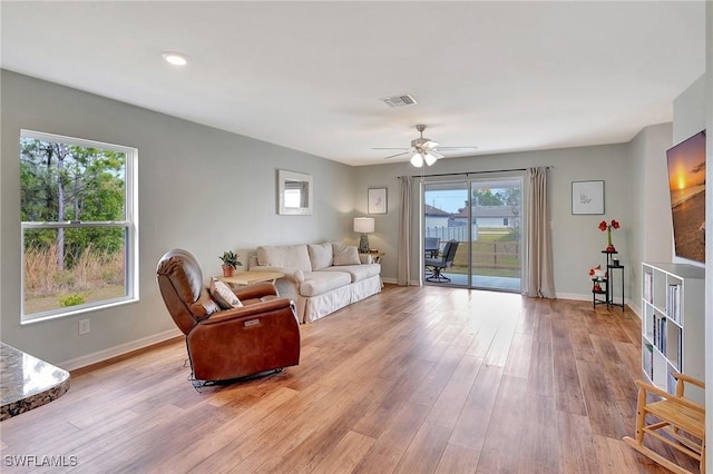 living room with ceiling fan, a healthy amount of sunlight, and light hardwood / wood-style floors