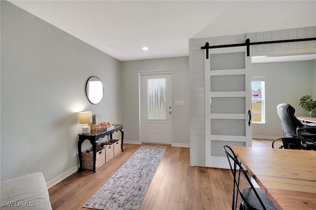 entryway featuring a barn door, plenty of natural light, and light hardwood / wood-style floors