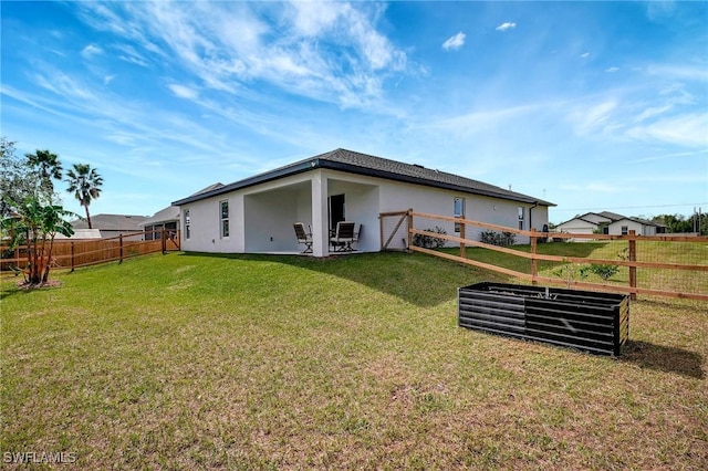 rear view of house featuring a yard