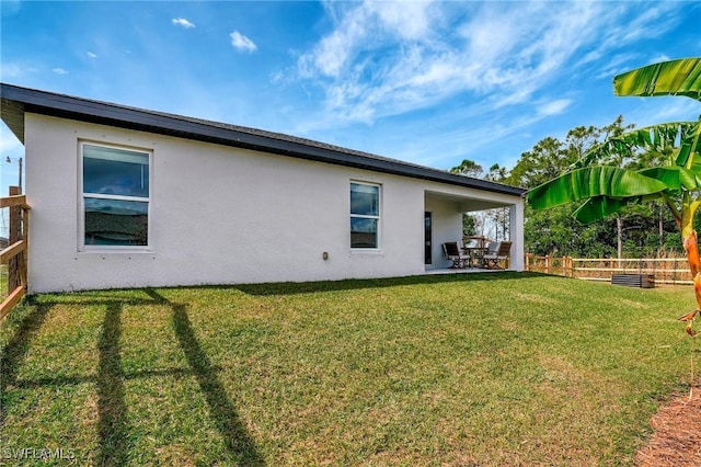 back of property with a lawn and a patio area