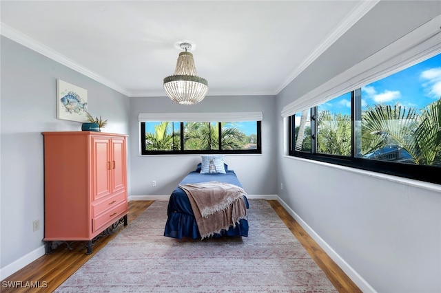 bedroom with multiple windows, crown molding, hardwood / wood-style floors, and a notable chandelier