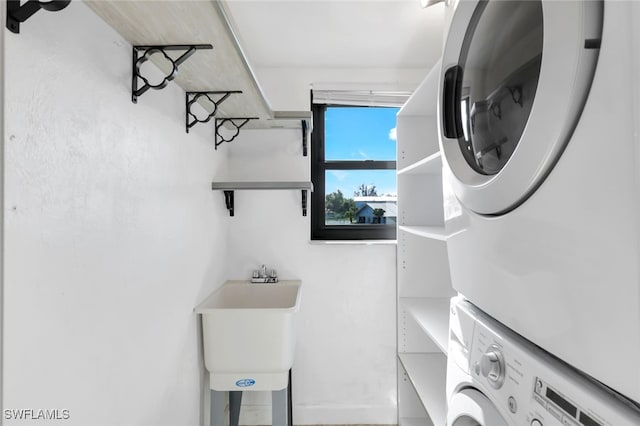 washroom featuring sink and stacked washing maching and dryer