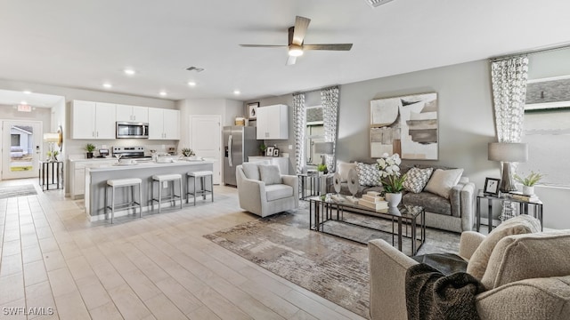 living room featuring light hardwood / wood-style floors and ceiling fan