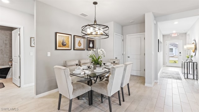 dining space featuring recessed lighting, light wood-style flooring, baseboards, and an inviting chandelier