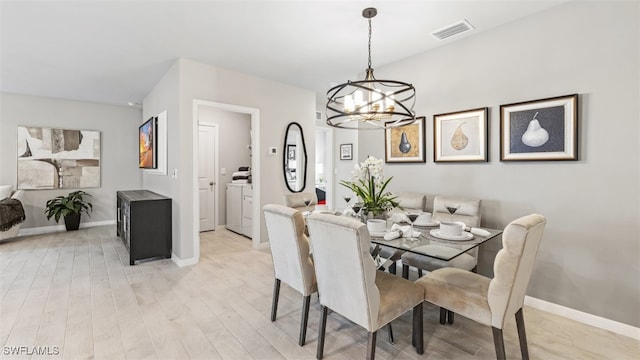 dining room featuring light wood-type flooring, an inviting chandelier, baseboards, and visible vents