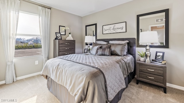 bedroom with light carpet, visible vents, and baseboards