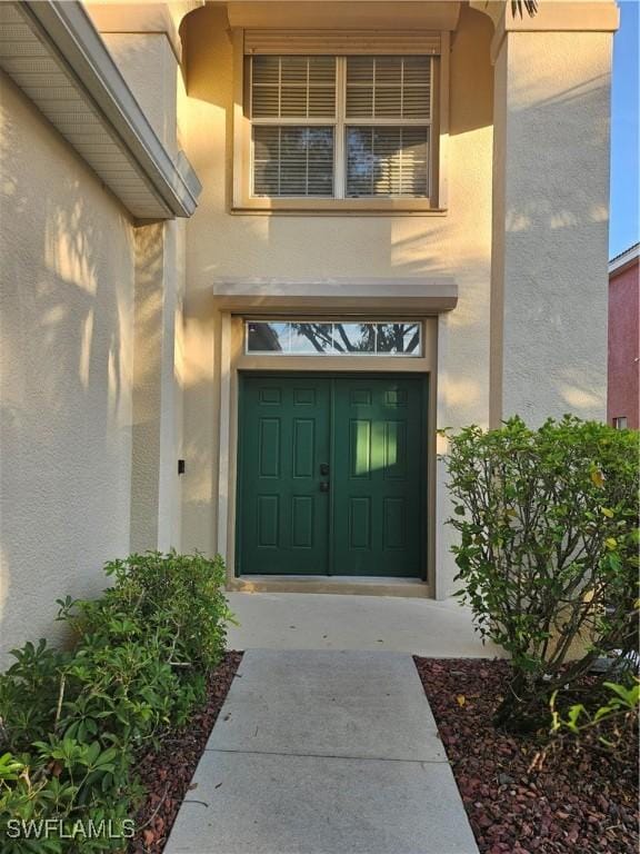 entrance to property featuring stucco siding