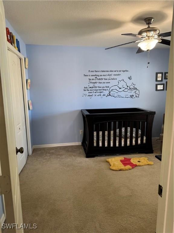 carpeted bedroom featuring baseboards and a ceiling fan