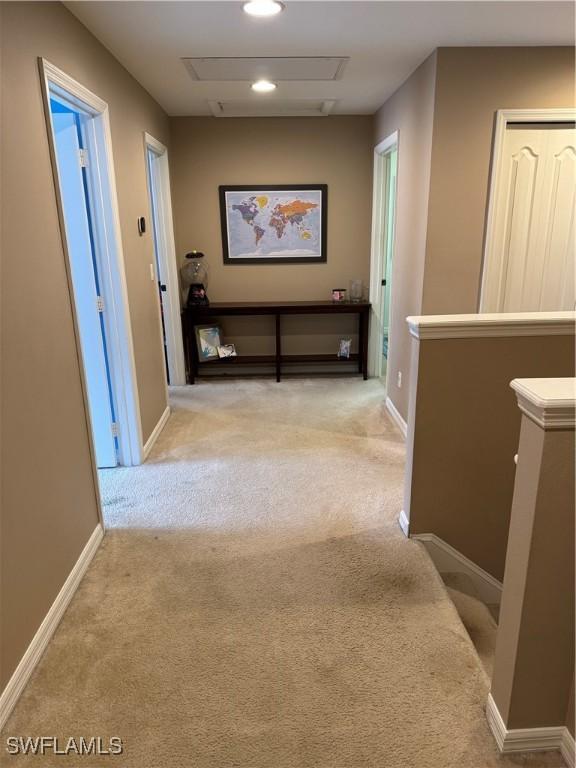 hall with recessed lighting, carpet, baseboards, and an upstairs landing